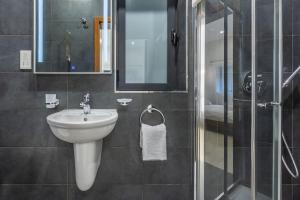 une salle de bain avec un lavabo et une douche en verre dans l'établissement St. Julian's Urban Escape, à San Ġiljan 15 autres photos