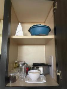Apartamento tipo estudio في Mérida: خزانة مع بعض الأطباق وغيرها من مواد المطبخ عليها