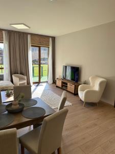 een woonkamer met een tafel en stoelen en een televisie bij Apart-Hotel Crown Bansko 2 in Bansko