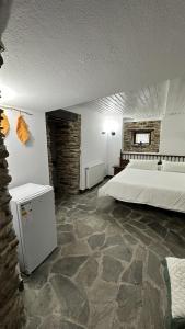 1 dormitorio con 1 cama grande y suelo de piedra en Aldea Lamacido, en Loiba