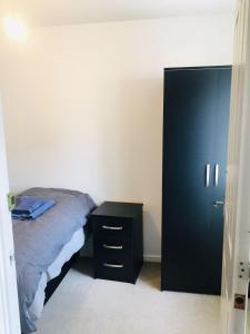 ein Schlafzimmer mit einem Bett und einem schwarzen Schrank in der Unterkunft Caroline Court House in Burton upon Trent