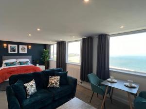 スカーバラにあるThe Marlborough Sea View Holiday Apartmentsのベッドルーム1室(ベッド1台、ソファ、テーブル付)