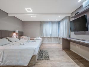 Habitación de hotel con cama y TV de pantalla plana. en Alameda Felice Hotel, en Gramado