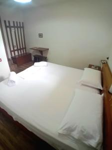 a large white bed in a room at Guesthouse Çelo in Gjirokastër
