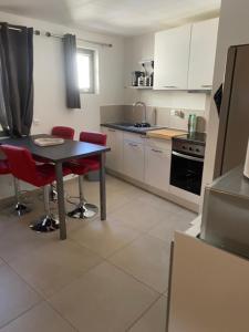 a kitchen with a table and some red chairs at LE CUPIDON in Montmeyan +22 photos