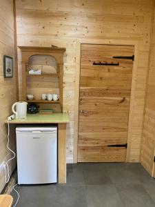 una pequeña cocina con nevera y puerta en Le Bel appartement de Montagne, en Bellevaux