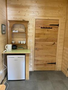 małą kuchnię z lodówką i drzwiami w obiekcie Le Bel appartement de Montagne w mieście Bellevaux