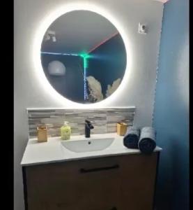 La salle de bains est pourvue d'un lavabo et d'un miroir. dans l'établissement LE CUPIDON, à Montmeyan