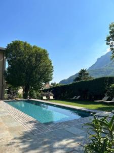 ein Schwimmbad in einem Garten mit Bergen im Hintergrund in der Unterkunft Villa Sardino in Settimo Vittone