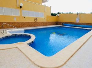 a large swimming pool in front of a building at Excelente Apartamento Ático in Algorfa