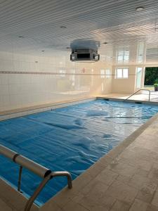 a large indoor swimming pool with blue water at Buitenplaats Ureterp in Ureterp