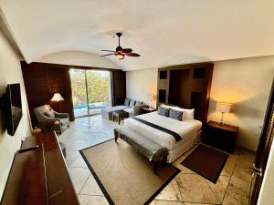 a bedroom with a large bed and a living room at Hotel Hacienda San Pancho in San Francisco