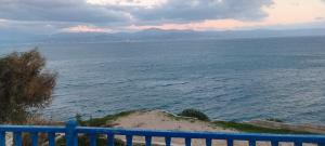 a view of the ocean from a blue fence at Καραμπεικο in Piso Livadi
