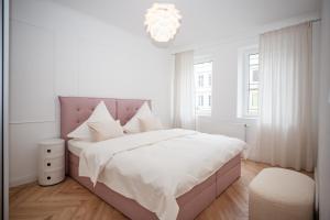 a white bedroom with a bed and a chandelier at Hanse Villa - Apartment Hamburg in Lübeck