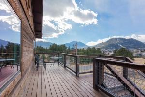 een balkon met een tafel en stoelen en bergen bij Coyote Mountain Lodge in Estes Park