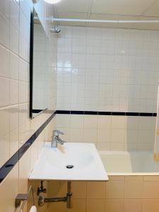 y baño con lavabo y bañera. en Apartamentos Zaragoza Coso, en Zaragoza