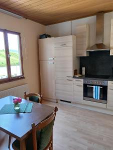 eine Küche mit einem Holztisch und eine Küche mit einem Herd in der Unterkunft Gästehaus Herda in Briedel + 16 Fotos