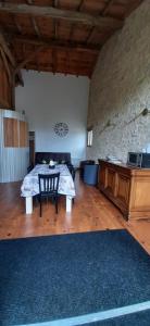 ein großes Wohnzimmer mit einem Tisch und einem Klavier in der Unterkunft La Mirabelle in Montazeau