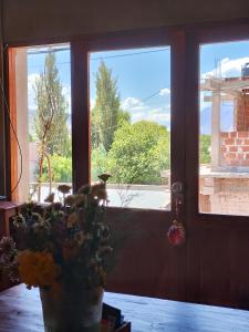 ein Zimmer mit einem Fenster und einer Topfpflanze vor einer Tür in der Unterkunft susurros del viento in Tilcara