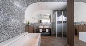 a bathroom with a tub and a sink and a mirror at PLAZA INN Bad Rappenau in Bad Rappenau