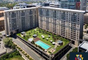 an apartment building with a green roof with a swimming pool at Sandton Lux, CBD, 2 Bedroom & 2 Ensuite, No Load shedding in Johannesburg