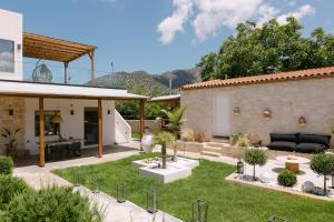 a garden with a patio and a house at Villa Aldea - Luxury Boho Style in Melidhónion