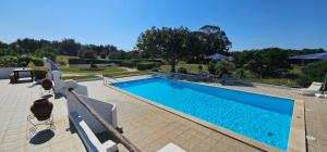 uma piscina com água azul num quintal em Quinta do Lagar - Rural Retreat by the Beach #10 em Albufeira