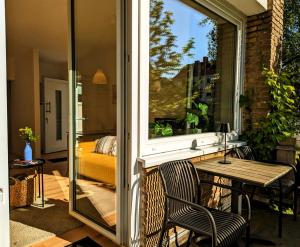 Apartment mit Balkon in Hannover-Ahlem في هانوفر: فناء مع طاولة وكراسي ونافذة
