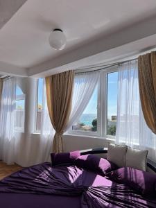 a bedroom with a large bed with a large window at Accommodation Royal Azur in Dobra Voda