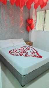 a bed with a bunch of red balloons above it at apartahotel Cartagena in Cartagena de Indias
