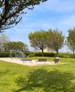 een park met twee banken en een glijbaan bij Villa Frans Lichtrijk appartement 2slpk in Oostende