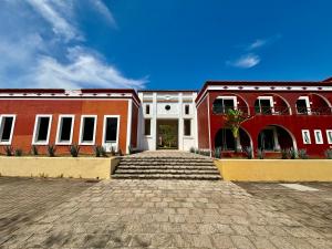 Hotel Hacienda San Pancho في سان فرانسيسكو: مبنيان أحمر وبيضاء مع شارع بالحصى