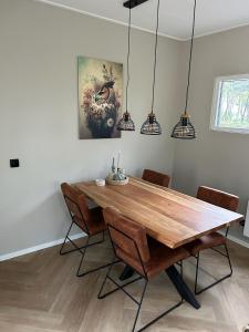 een eetkamer met een houten tafel en stoelen bij Bos chalet Hellendoorn met Hottub in Haarle