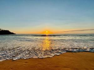 una puesta de sol en una playa con el océano en Hotel Hacienda San Pancho, en San Francisco