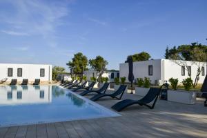 a row of chairs by a pool at a resort at Holiday Homes Ahil 7&8 in Pakoštane