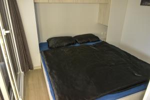 a bed in a small room with black sheets at Holiday Homes Ahil 7&8 in Pakoštane +30 photos