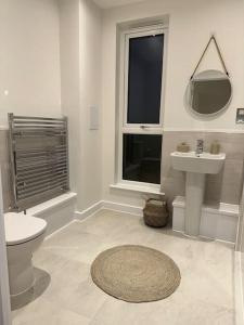 bagno bianco con servizi igienici e lavandino di RomaVita Apartment near Heathrow a Hayes