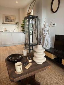 soggiorno con vaso su tavolino di RomaVita Apartment near Heathrow a Hayes