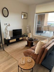 un soggiorno con divano e tavolo di RomaVita Apartment near Heathrow a Hayes