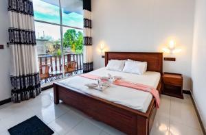 um quarto com uma cama e uma grande janela em The Amora em Arugam Bay