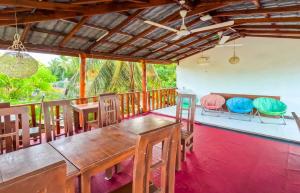 a dining room with a wooden table and chairs at The Amora in Arugam Bay