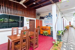 a dining room with a wooden table and chairs at The Amora in Arugam Bay