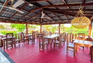 a restaurant with tables and chairs and a chandelier at The Amora in Arugam Bay