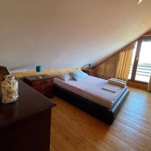 a bedroom with a bed and a desk and a window at Kaseta in Ulcinj