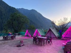 a group of tables and chairs in front of tents at Wild trip cafe in Kasol