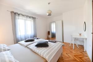 um quarto branco com 2 camas e uma secretária em Apartman Punta Sole em Zadar