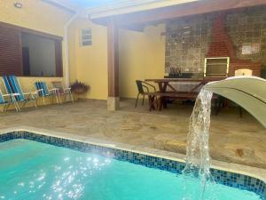 a swimming pool with a fountain in a yard at Casa Piscina Centro Serra Negra 500m Fontana Trevi in Serra Negra