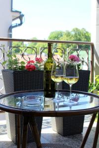 a glass table with a bottle of wine and two glasses at Apartmanový dom Stummerova in Topoľčany