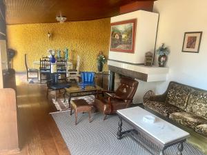 a living room with couches and chairs and a table at Casa Piscina Centro Serra Negra 500m Fontana Trevi in Serra Negra