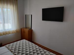 a bedroom with a flat screen tv on a wall at Apartments Vili in Umag